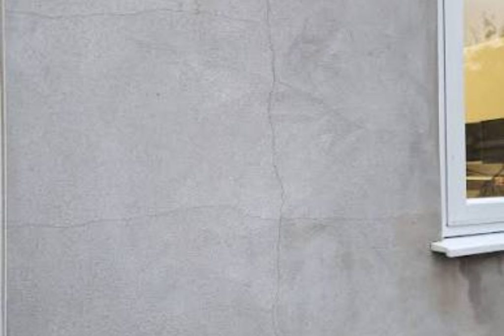 Cracked external render on a building facade, a common external cause of water leakage from wall