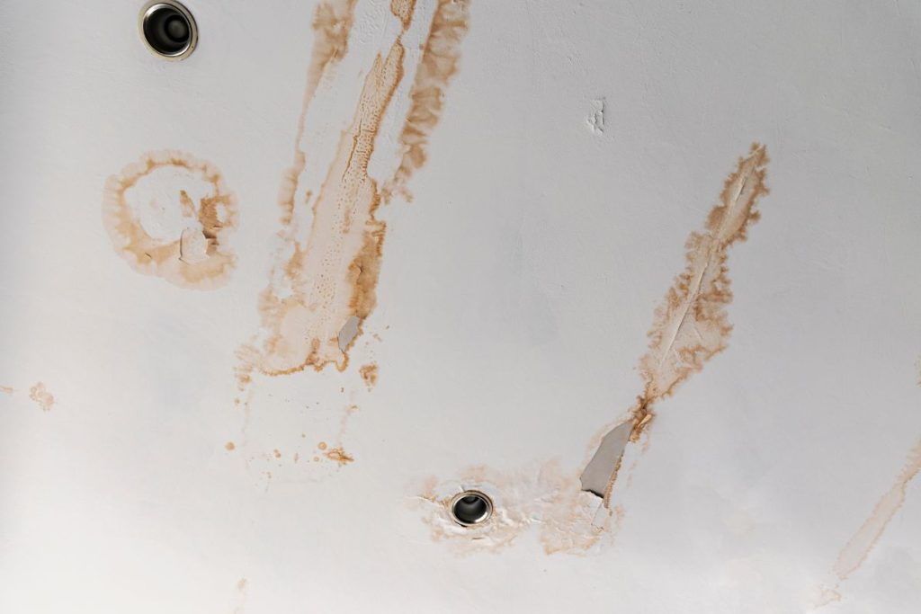HDB ceiling dripping water with a brown stain ring forming around the wet patch