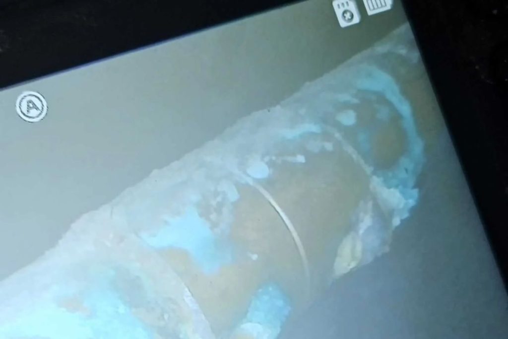 Insurance claim evidence laid out phone with ceiling leak photos, a leak inspection report