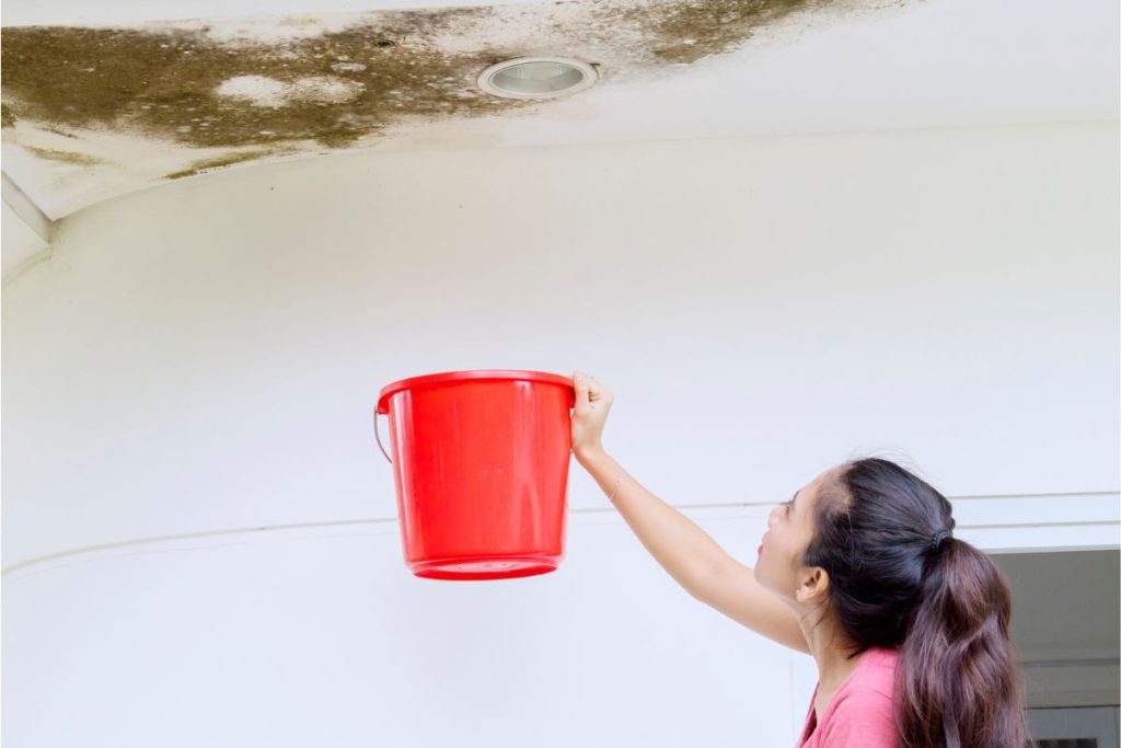 Water-stained HDB ceiling dripping into a bucket in a Singapore flat