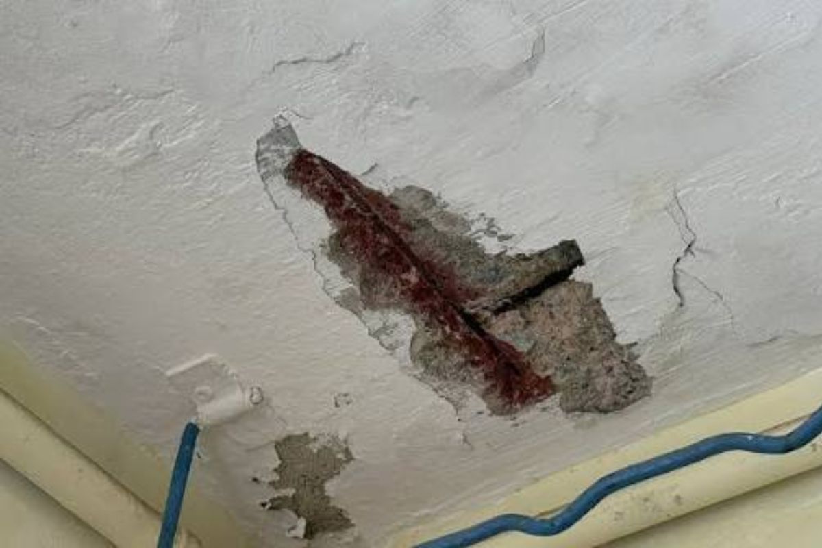 Exposed rusty rebar in a spalling concrete ceiling in a Singapore HDB flat